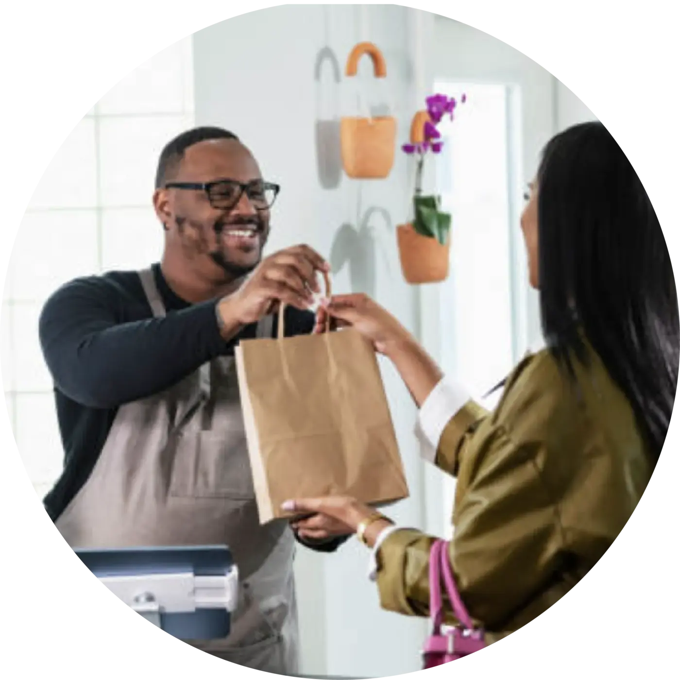 Business owner handing shopping bag to customer